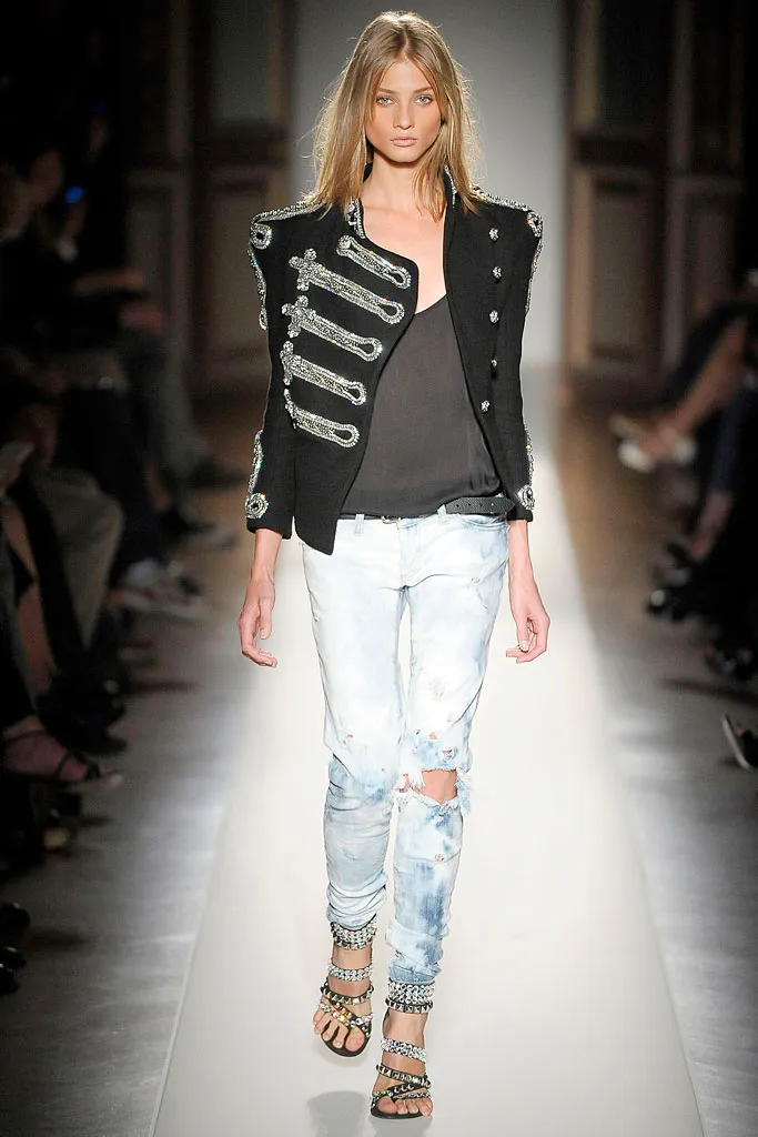 Runway model wearing a structured black military inspired jacket
